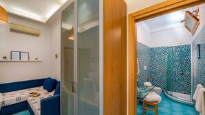 Un baño con ducha, inodoro con cerramiento de vidrio y lavamanos.
