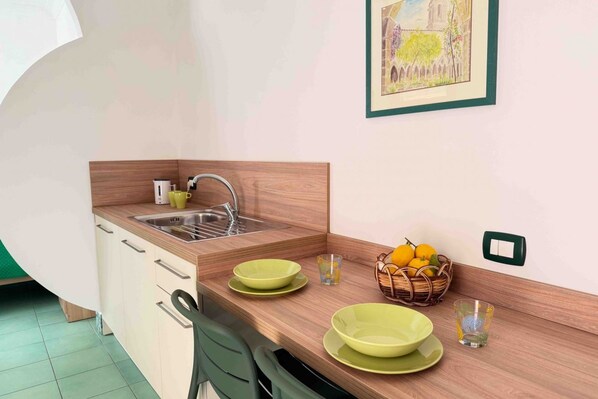 Une cuisine avec un plan de travail en bois, un évier et un interrupteur fixé au mur.