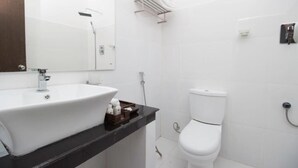A modern bathroom with a white sink, mirror, and toilet. - Pearl Royal Hotel (Colombo)