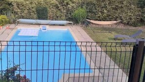 A rectangular swimming pool with a blue interior, surrounded by a metal fence. - House Vezac (Vezac)