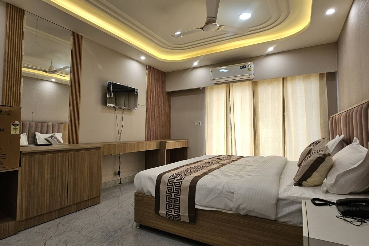 A modern bedroom with a bed, bedside table, and a mirror.