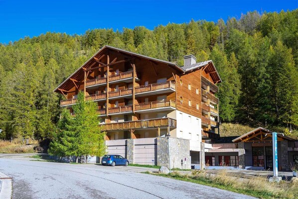 Situated in a forested area, this lodge features a stone entrance and balconies on each floor.