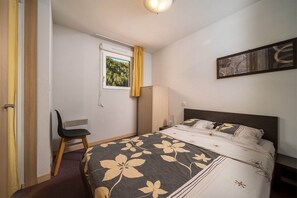 Cozy retreat with a single bed, chair, and table, perfect for a relaxing stay.