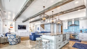 A spacious kitchen with a large island, white cabinetry, and stainless steel appliances. - Oceanfront Estate - Pool, Hot Tub, Pool Table, Bonus Boat- Exclusive Location (Hilton Head Island)
