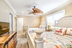 A bedroom with a bed, a dresser, a ceiling fan, and a window. - Oceanfront Estate - Pool, Hot Tub, Pool Table, Bonus Boat- Exclusive Location (Hilton Head Island)