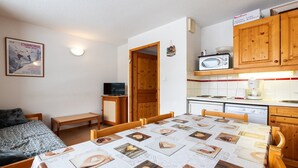 Une petite pièce agréable, dotée d’un lit, d’une table et d’un coin cuisine.
