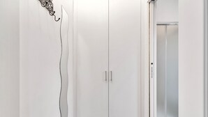 A white wardrobe with two doors and a small mirror. - Naviglio 13 - Welcomely (Milan)