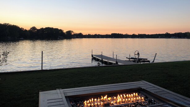 Une terrasse au bord du lac, avec un foyer et un quai.