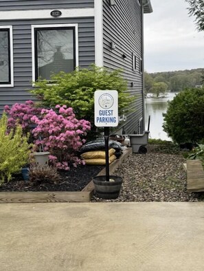 A guest parking sign in front of a building with a view of a lake. - All-Sports Pine Lake | Dock, Kayak, Fire Pit & Sunset Deck (Plainwell)