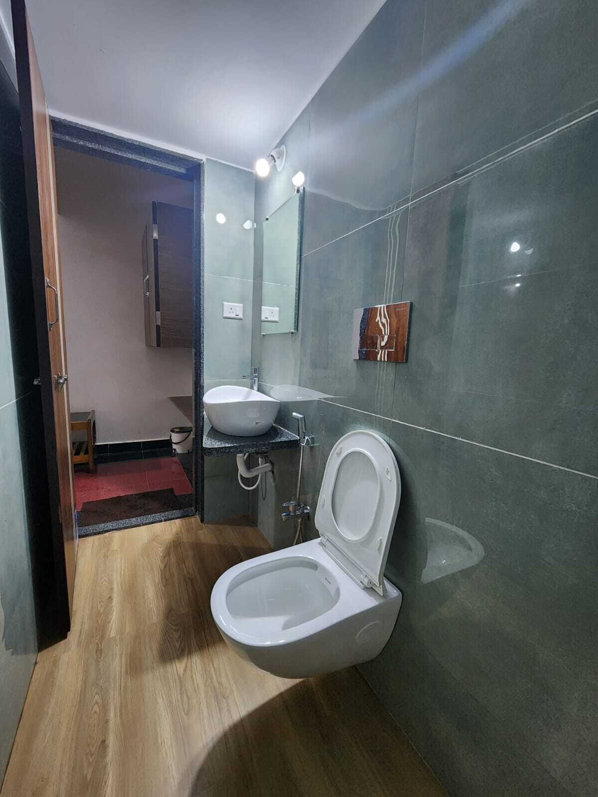 Une salle de bain moderne avec des toilettes, un lavabo et un miroir.