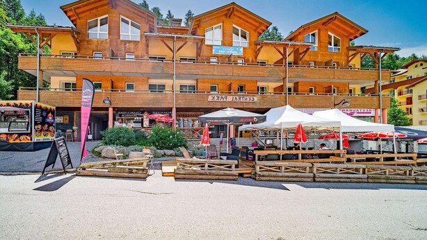 A multi-story wooden building with a restaurant named "Restaurant" on the ground floor. - Apartment in Alps near Ski Slopes (Allos)