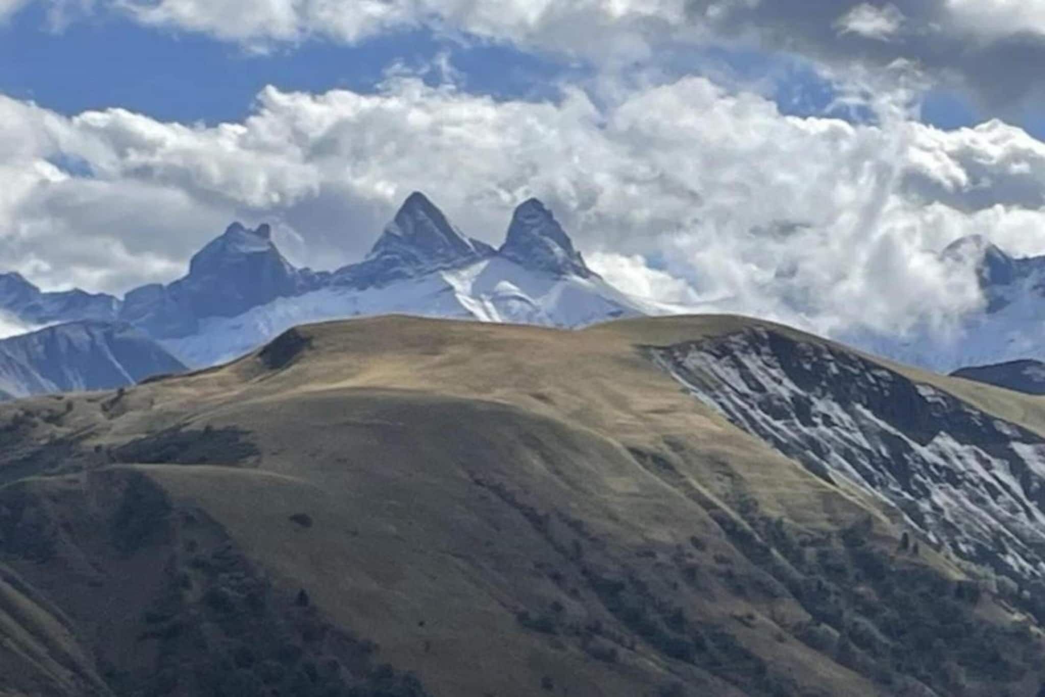 Un paisaje montañoso con picos nevados y cielo despejado.
