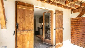 A wooden door with a glass panel, leading to a kitchen area with cabinets and a hanging light fixture. - Apartment in Saint-Sorlin near Ski Resort (Saint-Sorlin-d´Arves)