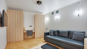 Ett modernt vardagsrum med en soffa, ett skrivbord och en stol.