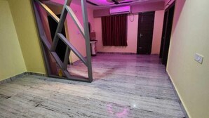 A room with a marble floor, a ceiling fan, and a purple-lit partition wall. - Eastern Heights (Ranchi)
