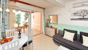 Un salon moderne comprenant un coin repas, un ensemble de canapés, une table à manger avec des chaises et une grande fenêtre avec des rideaux.