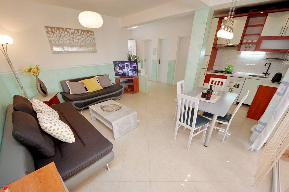 A modern apartment with a living room, dining area, and kitchen.