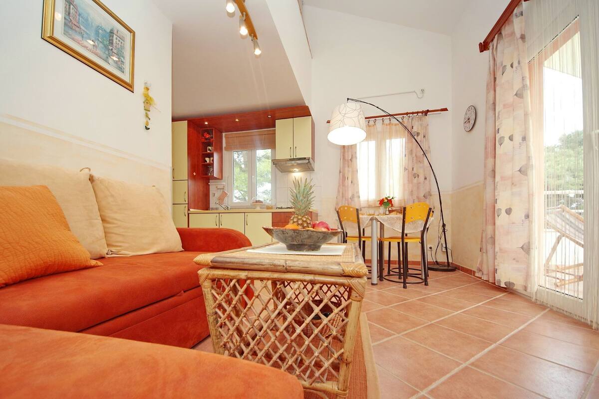 A cozy living room with a sofa and a dining area with chairs and a table.