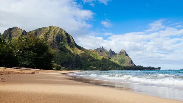 A beach with a mountainous backdrop and clear skies. - Perfect Private Getaway Minutes to Hanalei Bay! (Princeville)