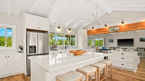 A spacious kitchen with a large island, white cabinetry, and a ceiling fan. - Perfect Private Getaway Minutes to Hanalei Bay! (Princeville)