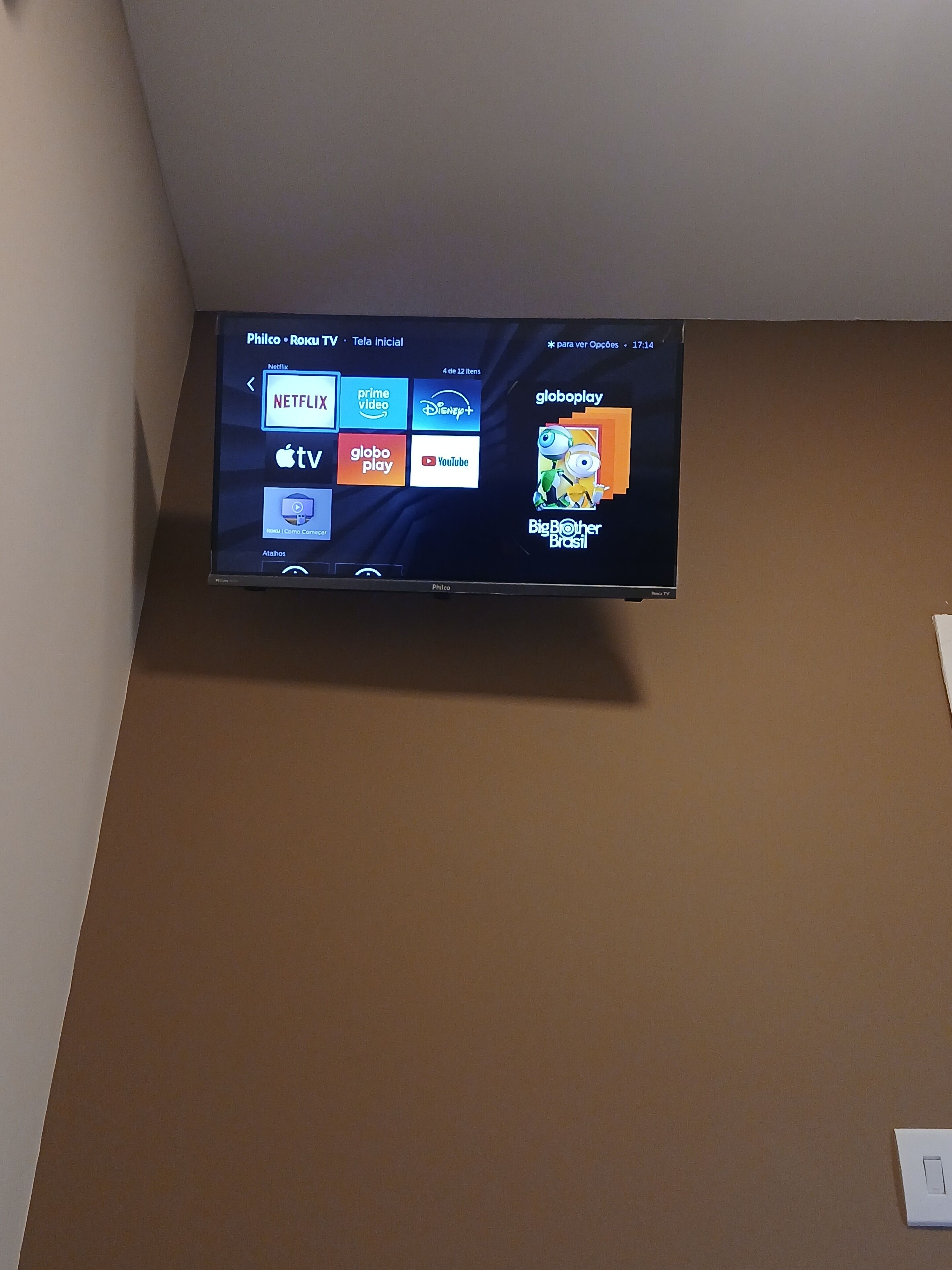 A flat-screen TV mounted on a wall displaying various streaming services.