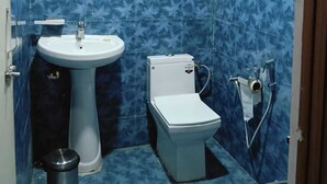 Une petite salle de bain comprenant des toilettes, un lavabo et un chauffe-eau.