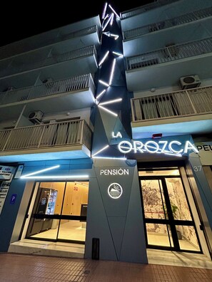 A modern building with a prominent 'Pension' sign and 'La Orozca' branding. - Pensión La Orozca (Benidorm)