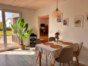 A dining area with a table set for four, a potted plant, and a hanging light fixture. - Hegau apartment, 2.5 rooms, 70sqm, free WiFi and parking spaces (Tengen)