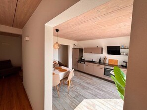 A modern kitchen with a dining area, wooden flooring, and a view of the living room. - Hegau apartment, 2.5 rooms, 70sqm, free WiFi and parking spaces (Tengen)