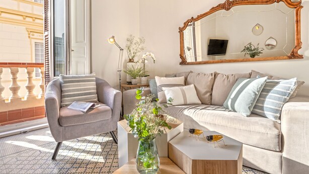 Un salon comprenant un canapé, un fauteuil, une table basse et un grand miroir.