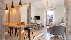 Une cuisine moderne avec un plan de travail en bois, des tabourets de bar et un panier de fruits.