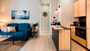 A modern kitchen with wooden cabinets, a black countertop, and a built-in oven. - Genteel Home Sagasta (Cádiz)