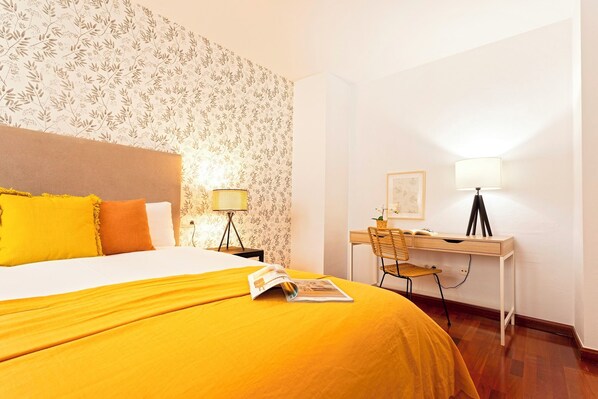 Une chambre d’hôtel avec un lit, un bureau et une chaise.