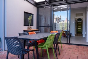 Enjoy dining al fresco in this inviting outdoor space with a table for four and comfortable seating.