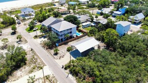 An aerial view of a coastal residential area with multiple houses, a beach, and a clear sky. - SPACIOUS COVERED RV LOT WITH A LARGE CONCRETE PAD (Port Saint Joe)