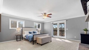 A bedroom with a bed, bedside table, lamp, and a ceiling fan. - Lakeside Hideaway, Fire-Pit | Near Marina (Rogers)