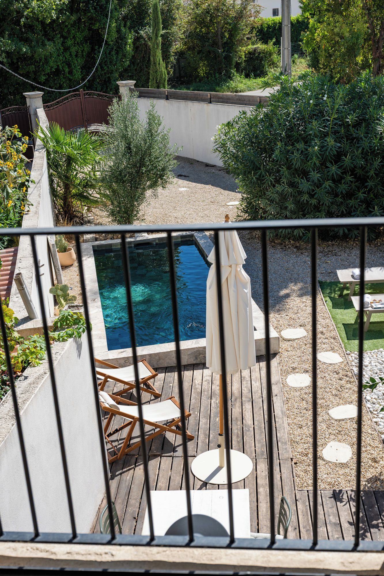 A pool area with a hot tub, deck chairs, and a pergola.