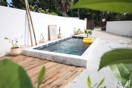 Una piscina al aire libre de temporada, sillones reclinables de piscina