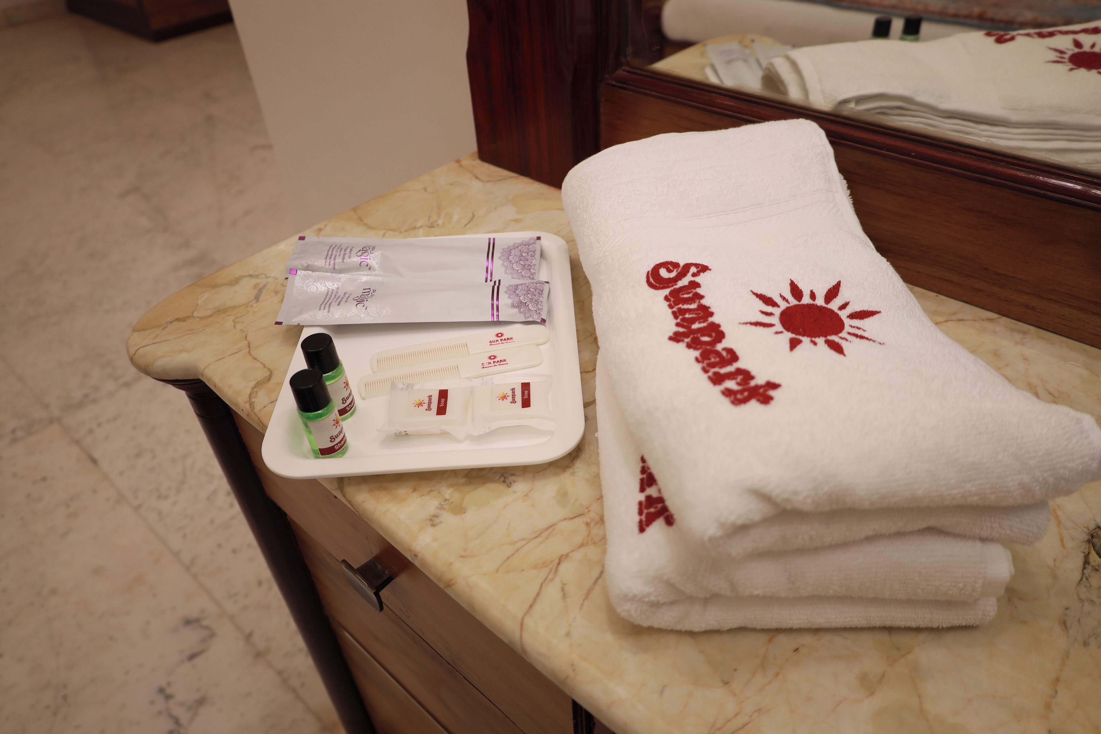 A bathroom counter with toiletries, a towel, and a mirror.
