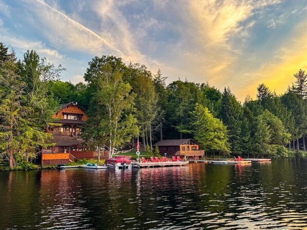 A lakeside cabin with a dock, surrounded by dense forest.