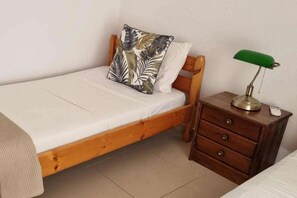 A single bed with a wooden frame, a bedside table with drawers, and a green desk lamp. - Plaka Elounda ..private Pool ..2 Beds..jaccuzi..parking..spinalonga/sea Views (Agios Nikolaos)