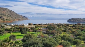 A coastal town with a mix of residential and commercial buildings, a large body of water, and hilly terrain. - Plaka Elounda ..private Pool ..2 Beds..jaccuzi..parking..spinalonga/sea Views (Agios Nikolaos)
