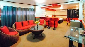 Een hotelkamer met een zithoek, een eethoek en een kitchenette.