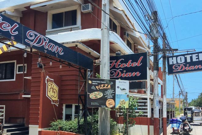 Un hotel llamado Hotel Dian, con un letrero llamativo y un menú de pizzas.