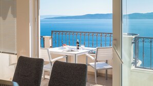 A balcony with a table and chairs, overlooking a body of water and distant land. - Villa Sandra - Private Pool (Pisak)