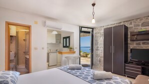A bedroom with a bed, a TV, a wardrobe, and a view of the sea. - Villa Sandra - Private Pool (Pisak)