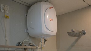 A white water heater with a control panel, connected to a showerhead. - Cozy hotel in terrific Purnia with WiFi, AC (Purnia)