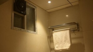 A bathroom with a window, a towel rack, and a shower area. - Cozy hotel in terrific Purnia with WiFi, AC (Purnia)