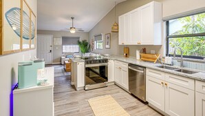A modern kitchen with white cabinets, stainless steel appliances, and a large window. - Dtwn Palm Harbor Condo: Walk to Water! (Palm Harbor)