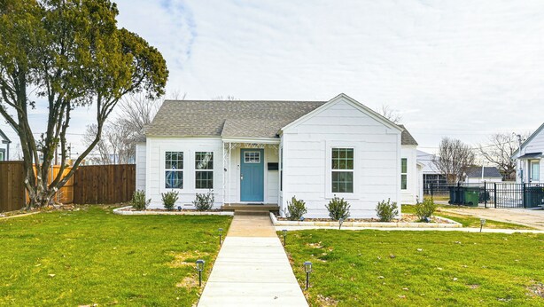 A single-story house with a front door, a small porch, and a well-maintained lawn.